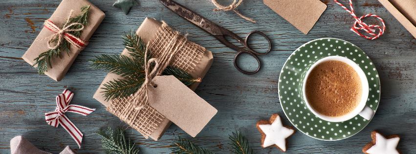 a flat lay of Christmas wrapping with a cup of coffee, as part of our coffee hamper ideas.