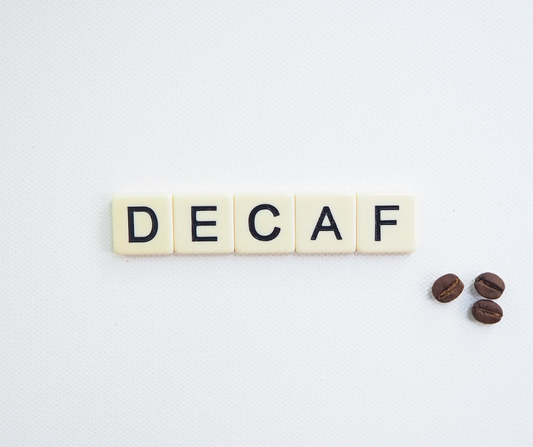 Is Decaf Coffee a Diuretic? scrabble tiles spelling out 'decaf' with three coffee beans on a white background