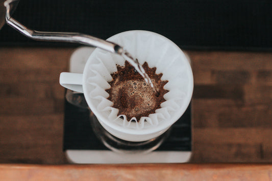 an overhead view of a paper coffee filter being filled with water.